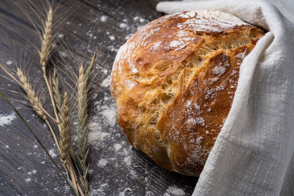 Pão caseiro fresco saindo do forno com casca dourada e crocante