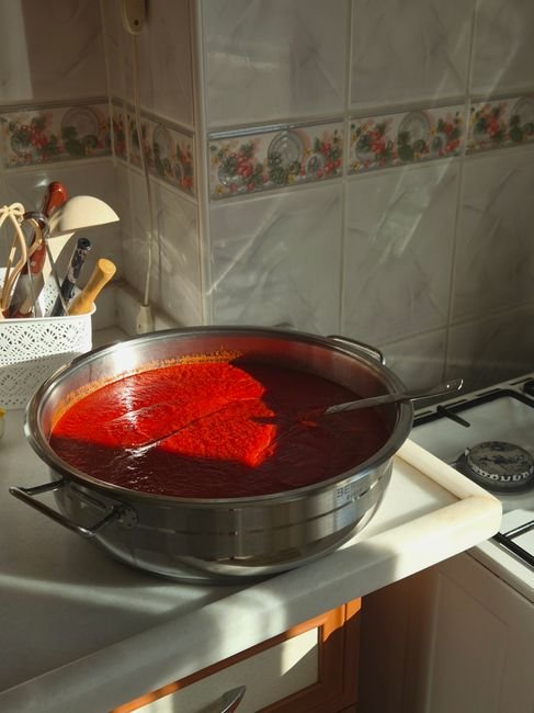 Panela com extrato de tomate caseiro sendo preparado no fogao