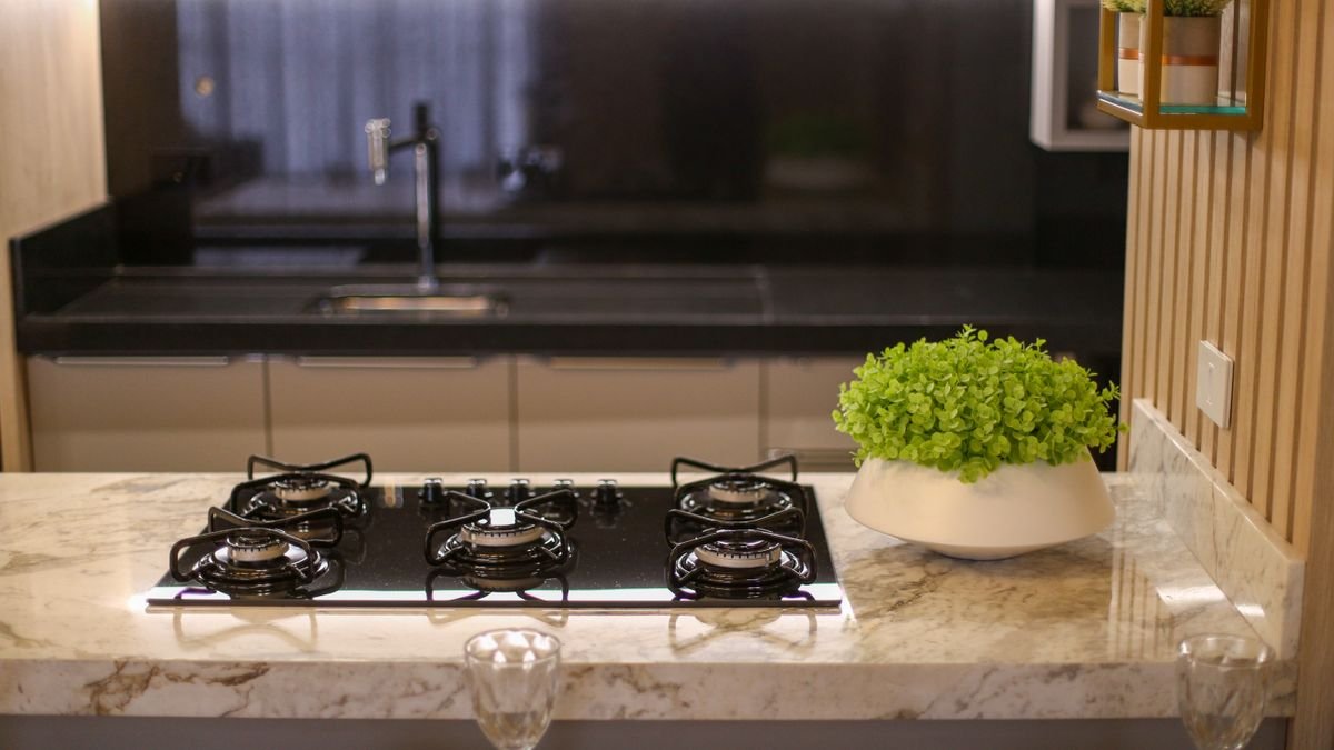 Cozinha moderna com cooktop e plantas, ambiente clean e funcional ideal para avaliar o espaço para a panela elétrica de arroz