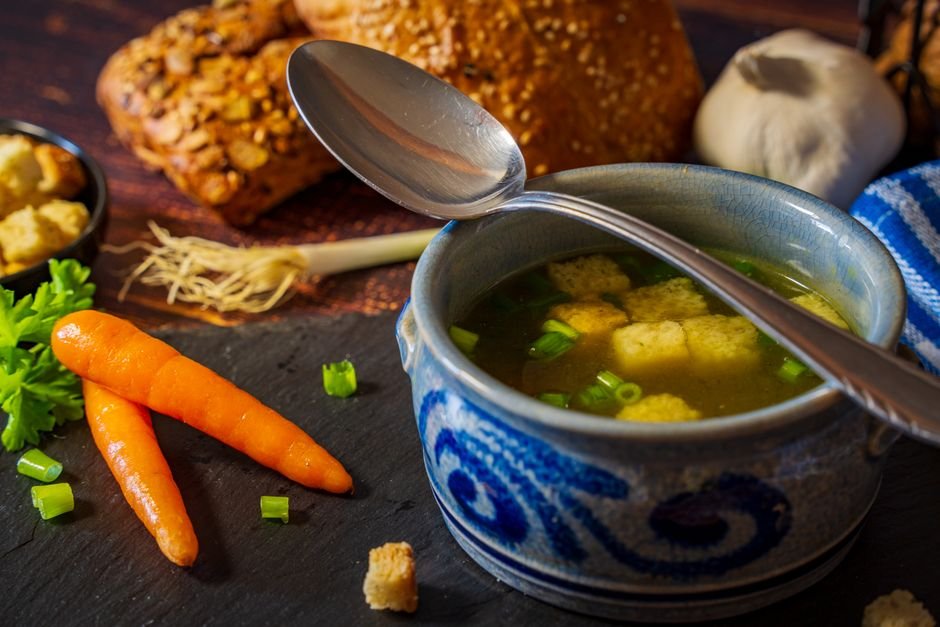 Tigela com caldo de galinha caseiro servido com ervas