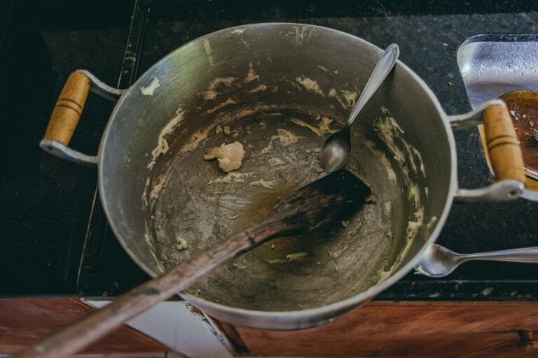 Panela de alumínio com fundo queimado e restos de comida carbonizada
