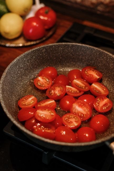 Tomates cereja sendo refogados em frigideira como etapa inicial do molho de tomate caseiro