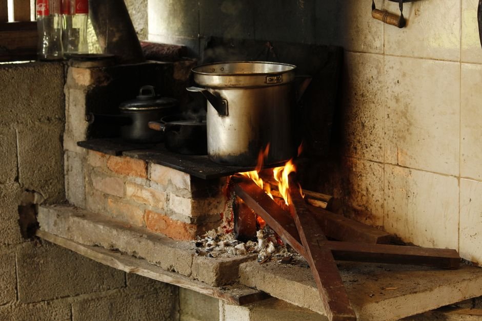Fogão a lenha com panela grande, simbolizando a cozinha tradicional mineira onde o requeijão caseiro é preparado