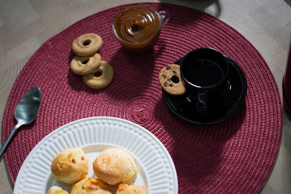 Doce de leite caseiro com biscoitos e café em mesa posta