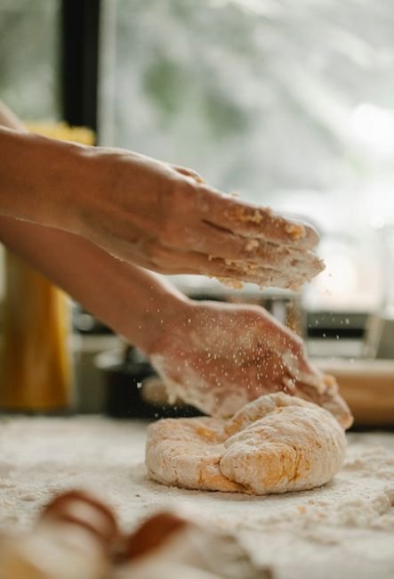 Mãos sovando massa de pão de forma caseiro