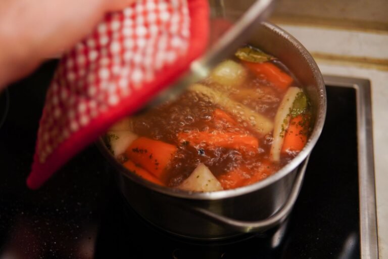 Caldo de legumes caseiro sendo preparado em panela com legumes frescos, ervas aromáticas e temperos naturais