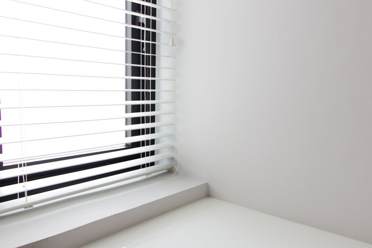 Persiana horizontal branca em janela de sala moderna e bem iluminada