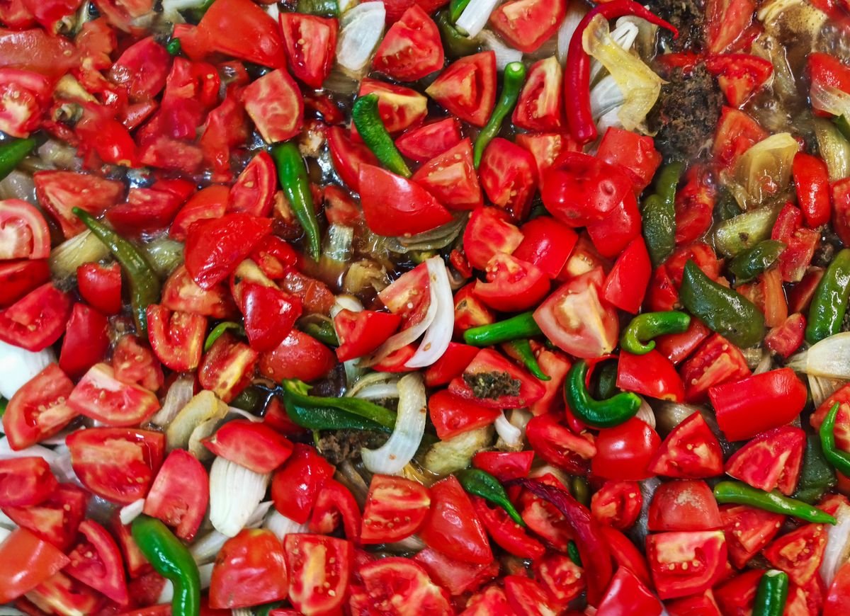 Tomates frescos sendo cozidos em panela para preparo de catchup caseiro natural