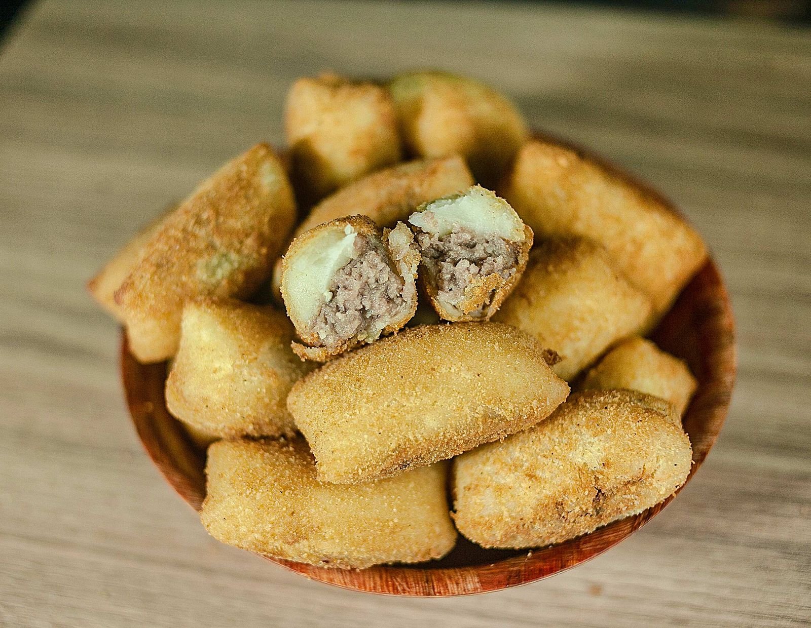 Coxinha cortada mostrando recheio cremoso de frango com catupiry dentro da massa
