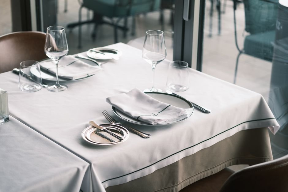 Mesa de restaurante elegante com toalha branca e talheres