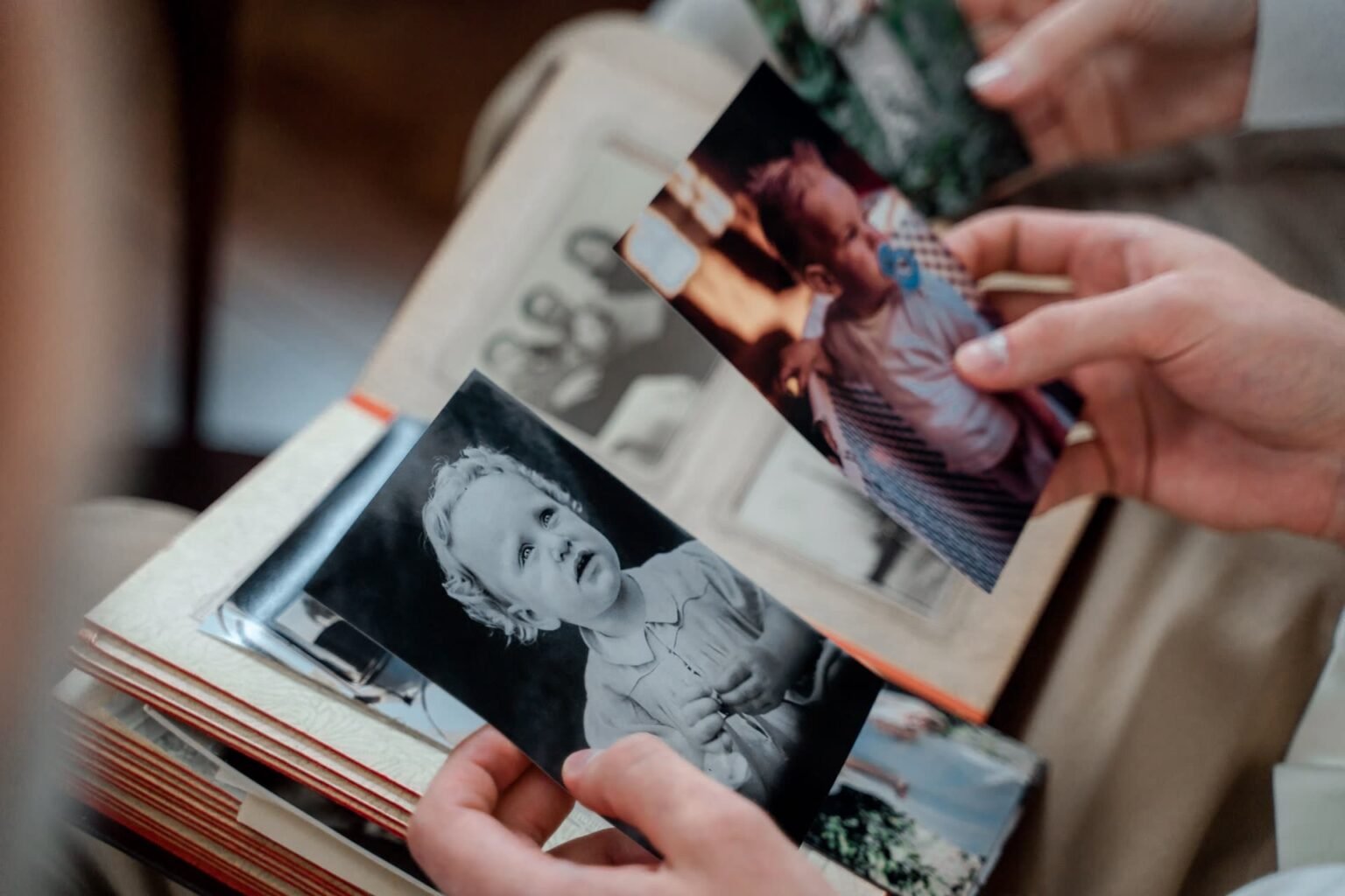 Pessoa folheando álbum de fotos de família com bolsos plásticos: como organizar fotos e lembranças sem danificar as imagens
