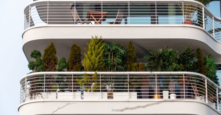Varanda de apartamento decorada com diversas plantas verdes em vasos
