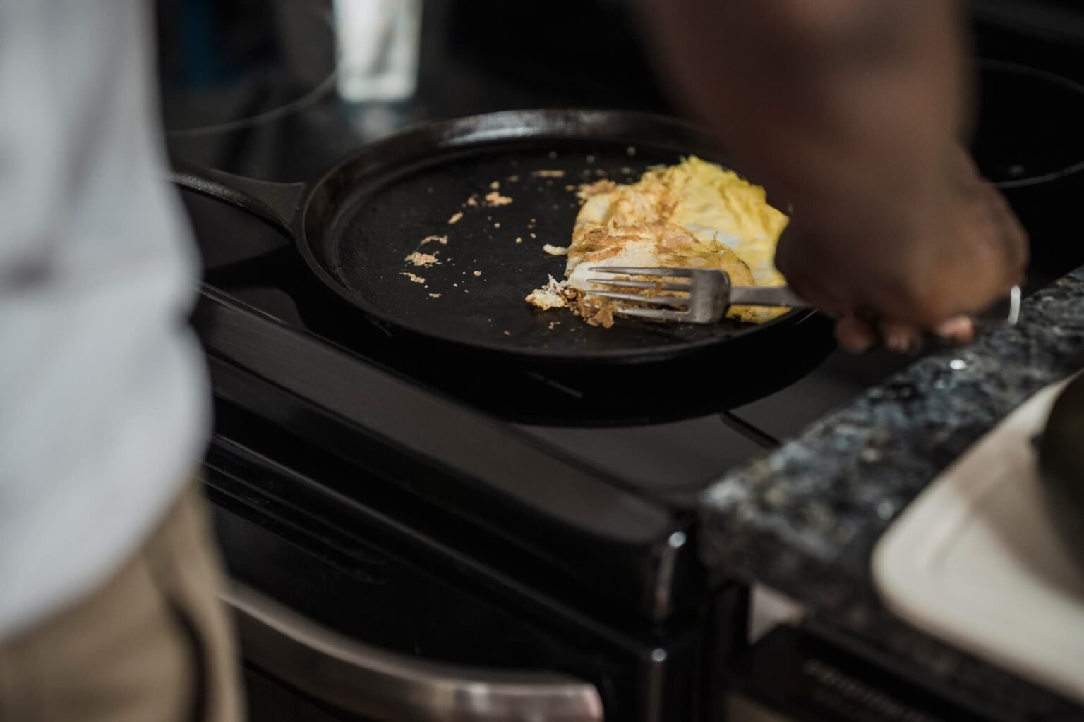 Omelete sendo preparada em frigideira de ferro fundido no fogão: teste do ovo para saber se o tempero está pronto