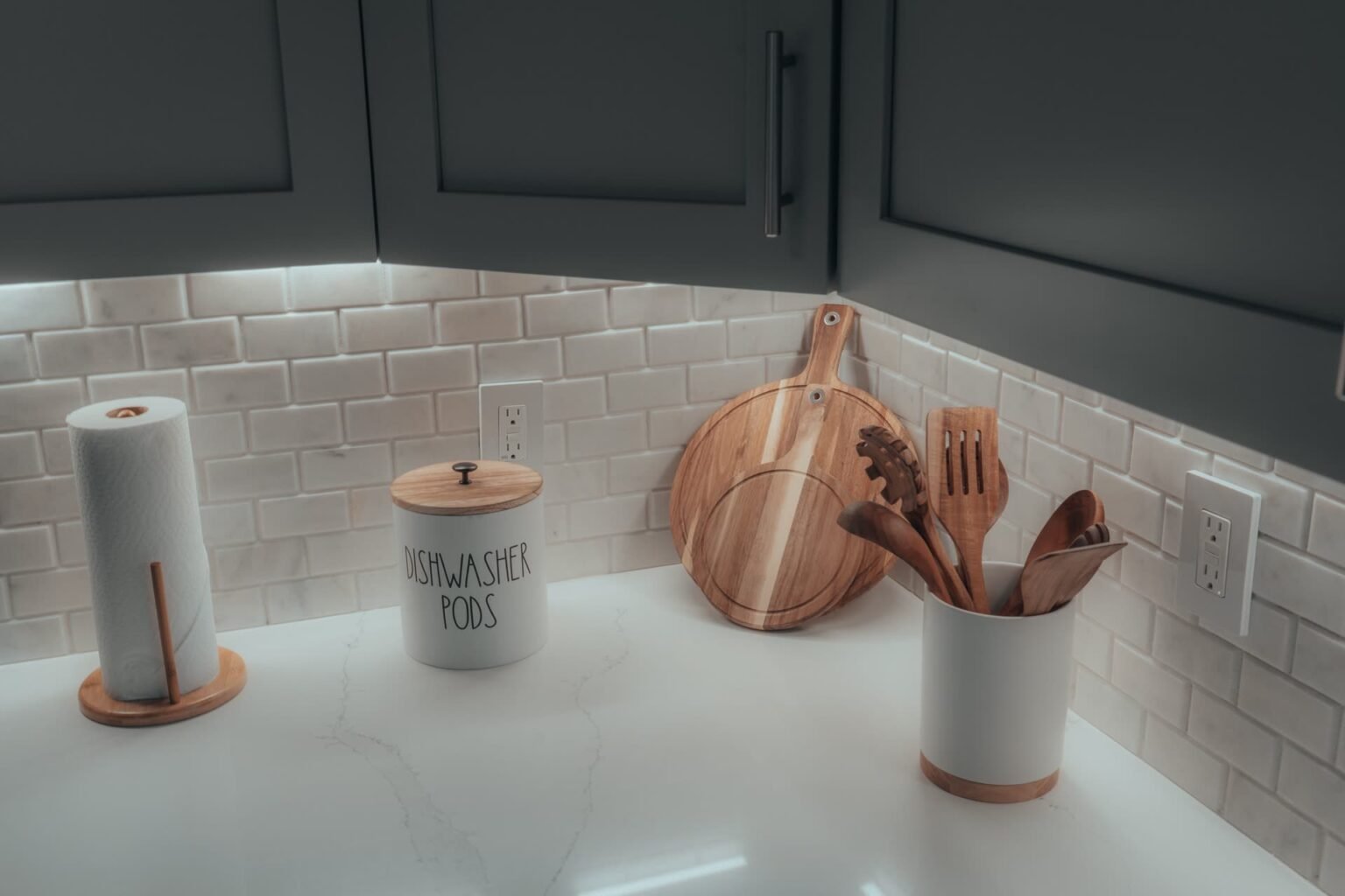 Bancada de cozinha organizada com utensílios de madeira e tábua de corte apoiada: guia de compra de tábua de corte
